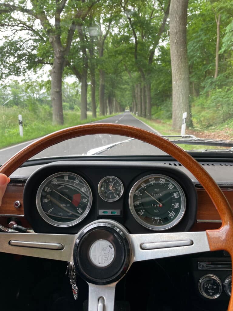 dials of 1972 alfa romeo giulia driving through country lane
