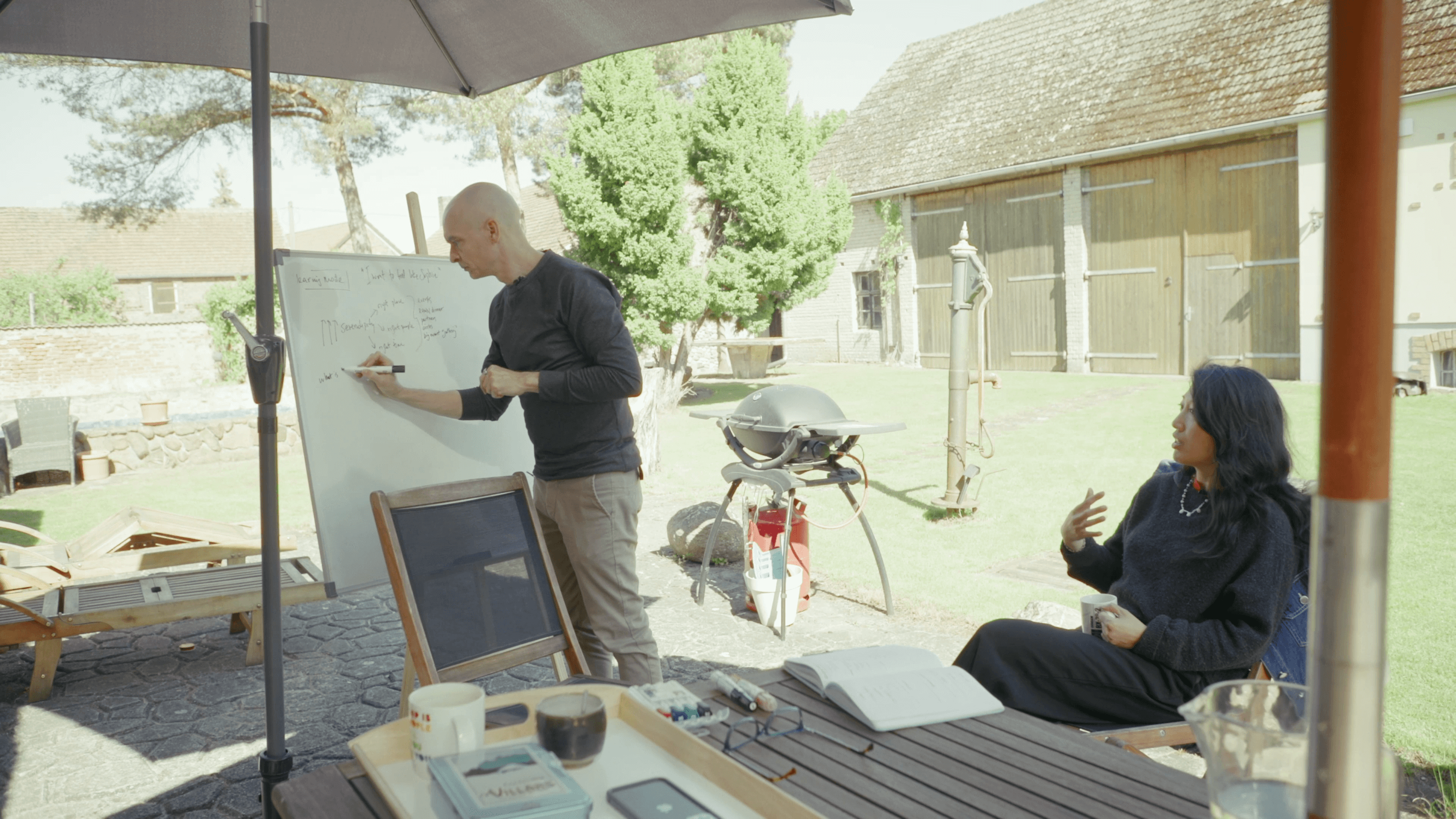 Matteo Cassese writing on a whiteboard while a client listens